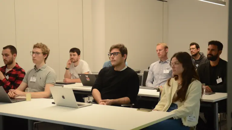 Menschen sitzen in Raum und schauen nach vorne