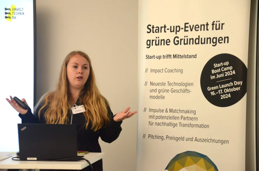 Evelyn Neifer steht neben Roll-up mit der Aufschrift Start-up Event für grüne Gründungen 