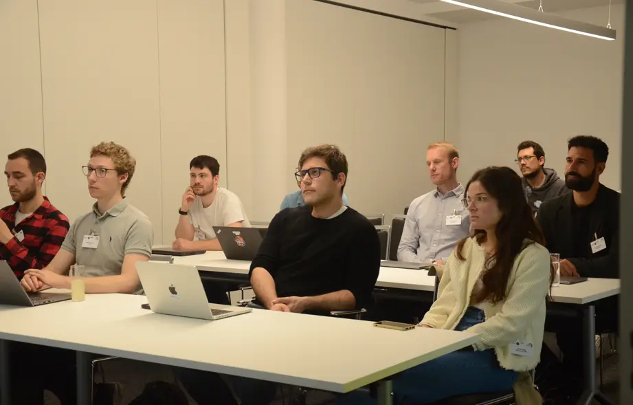 Menschen sitzen in Raum und schauen nach vorne