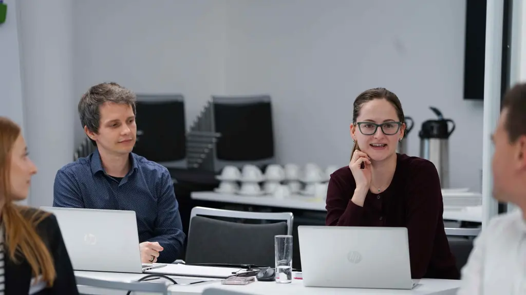 Zwei Menschen vor Computern in einem Besprechungsraum