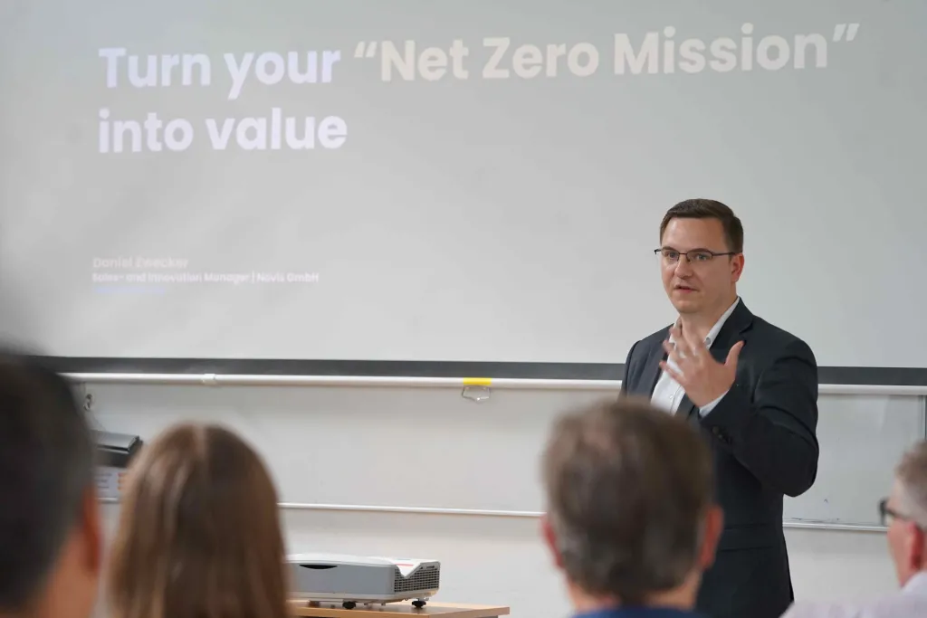 Mann hält Vortrag vor Tafel auf der steht: Turn your "Net Zero Mission" into value