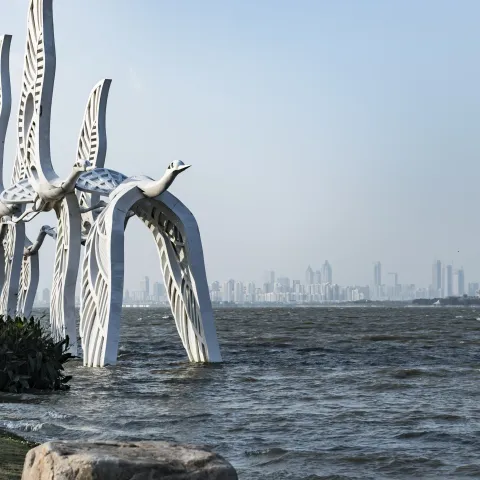 Mond-Bucht des Dushu-Sees in der Stadt Suzhou mit der Skyline im Hintergrund und einer Kranich-Großplastik im Vordergrund