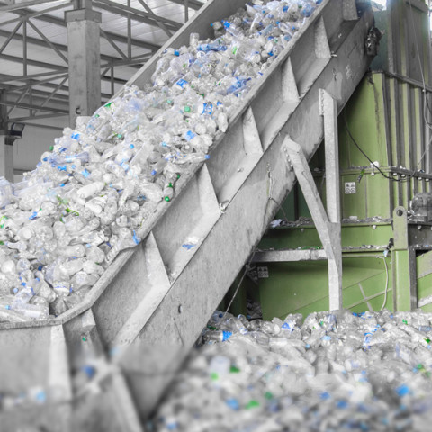 Closeup escalator with a pile of  plastic bottles at the factory for processing and recycling. 