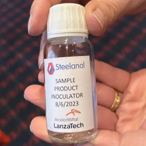 Eine Hand hält eine kleine Flasche auf der ein Kleber mit dem Logo von LanzaTech ist